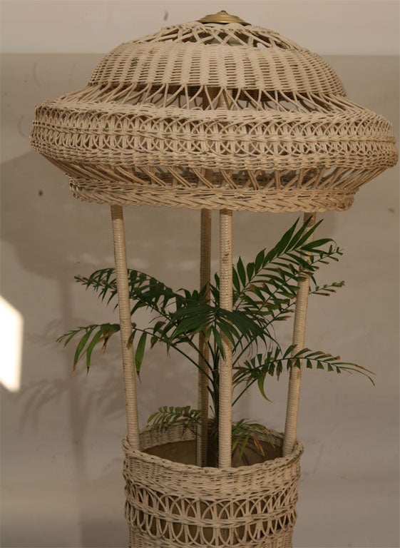 Unusual combination wicker floor lamp and planter, in old white paint.  Open lattice wickerwork as well as closely woven patterns to base and dome shade. Turned wooden feet.  From the extensive CORNER HOUSE ANTIQUES inventory of quality American